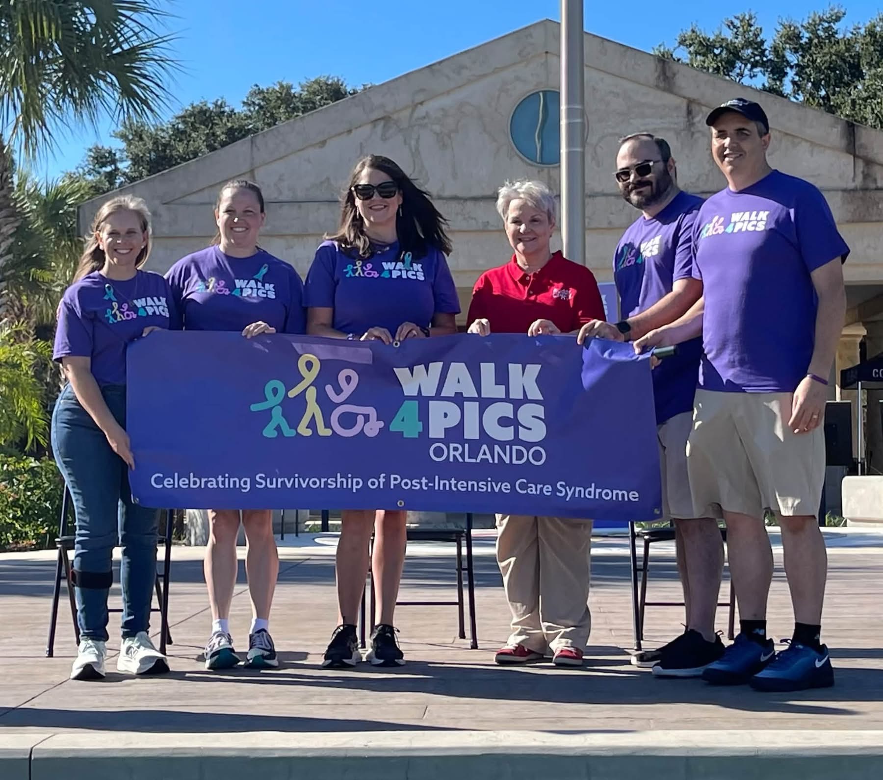 Michael and fellow participants hold the Orlando Walk4PICS banner on the park stage.
